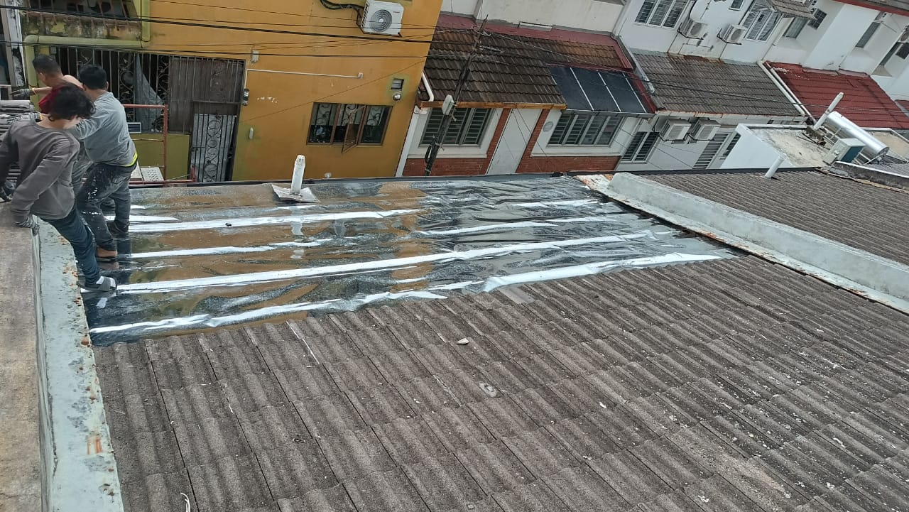 旧屋顶漏水，磨损的瓦片上盖着临时帆布